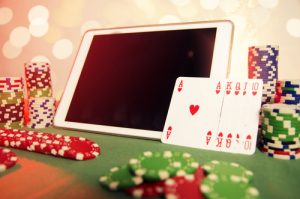concept de poker en ligne avec une tablette et une pile de jeton de casino