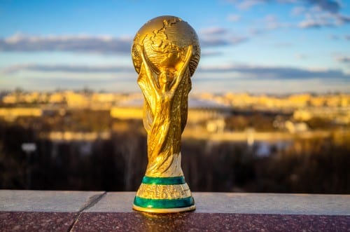 illustration de la coupe du monde posée sur le rebor d'un mur surplombant une ville